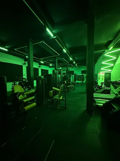 Área de musculação - Equipamentos com iluminação verde neon moderna